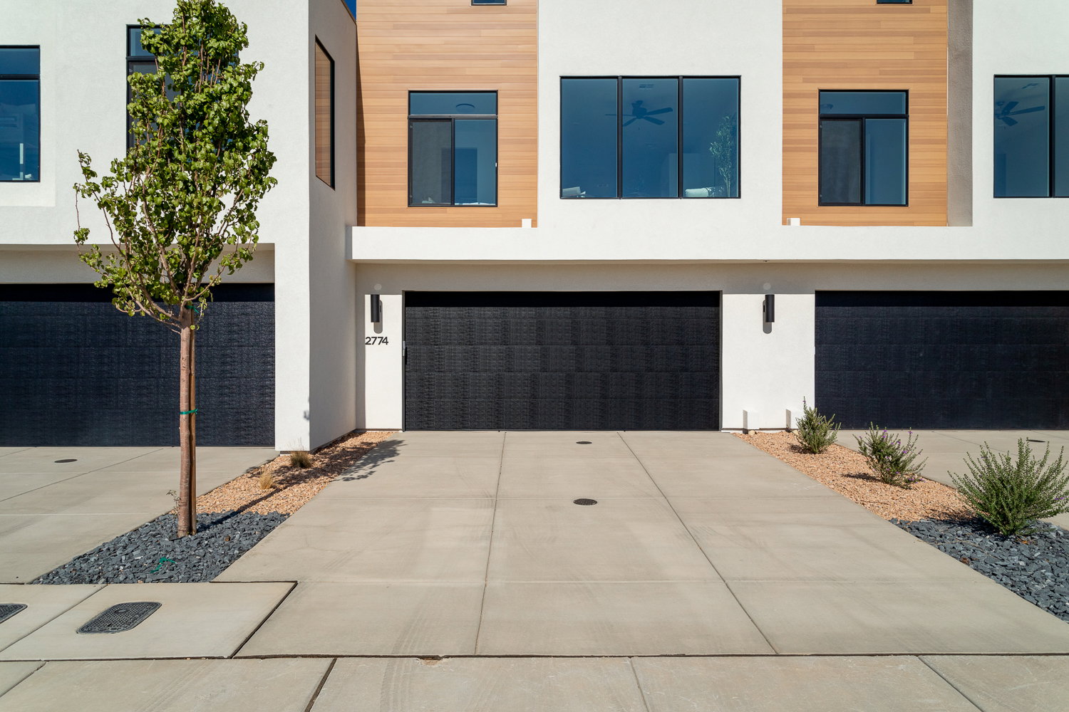 Modern home with a garage, stucco siding, and driveway