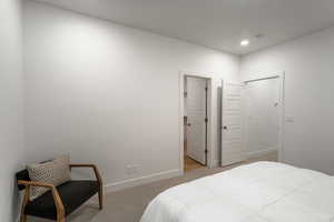Bedroom featuring light carpet and baseboards