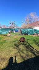 View of grassy yard featuring an outdoor fire pit