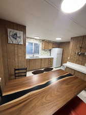Unfurnished dining area with wood walls and a sink