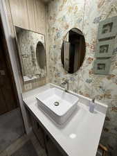 Bathroom with vanity and wallpapered walls