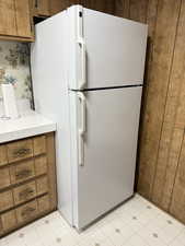 Kitchen with freestanding refrigerator, light countertops, wood finish cabinetry, and wallpapered walls