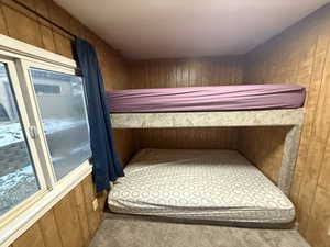 Carpeted bedroom with wooden walls