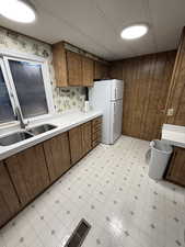 Kitchen with light floors, light countertops, freestanding refrigerator, and wood finish cabinetry