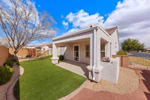 Rear view of house with a fenced backyard, stucco siding, and a patio