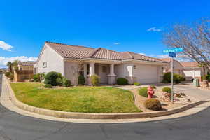 Mediterranean / spanish-style home featuring stucco siding, an attached garage, a tile roof, concrete driveway, and covered porch