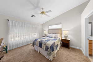 Bedroom with lofted ceiling, a ceiling fan, and light carpet