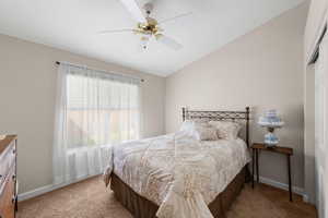 Bedroom featuring ceiling fan, lofted ceiling, a closet, and light carpet