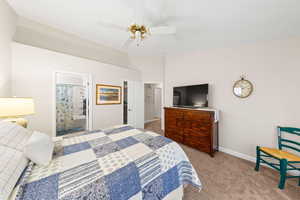 Bedroom featuring light colored carpet, ceiling fan, and ensuite bath