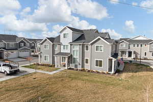 View of front of house featuring a residential view, board and batten siding, roof with shingles, a front lawn, and covered porch