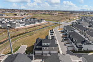 Aerial view of property and surrounding area featuring nearby suburban area and a large body of water