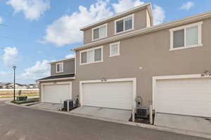 Back of property featuring stucco siding and a garage