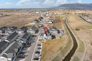 Aerial view of property and surrounding area with nearby suburban area and a mountainous background