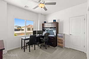 Office area with a ceiling fan and light carpet