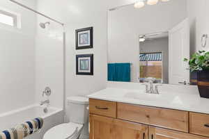 Full bath with vanity, shower / tub combination, and ceiling fan