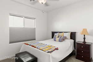 Carpeted bedroom featuring a ceiling fan