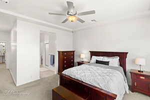 Carpeted bedroom featuring ceiling fan and ensuite bath
