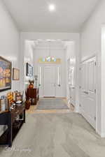 Entrance foyer with light carpet and suspended lighting