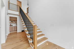 Staircase with wood-type flooring and a high ceiling