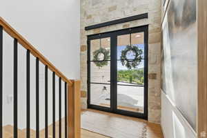 Foyer entrance with french doors and light wood-type flooring