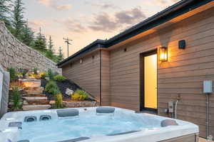 View of home's exterior featuring a hot tub and a patio