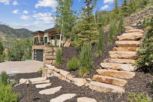 View of yard with a mountain view, an attached garage, and concrete driveway