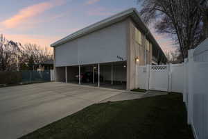 View of property exterior with a gate, a carport, and concrete driveway