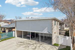 View of side of home featuring a gate, a carport, and driveway