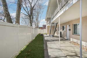 Fenced backyard featuring stairway and a balcony