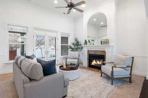 Living room with a high ceiling, a ceiling fan, a glass covered fireplace, recessed lighting, and oFormal living room with mountain views molding