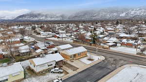 Snowy aerial view featuring a residential view and a mountain view