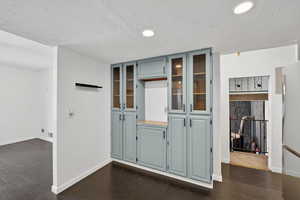 Interior space featuring dark wood-type flooring, recessed lighting, and a textured ceiling