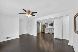 Unfurnished living room featuring dark wood-style flooring, ceiling fan, and recessed lighting