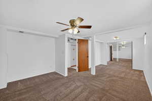 Unfurnished room with ceiling fan and dark carpet