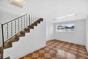 Staircase with parquet flooring and baseboards