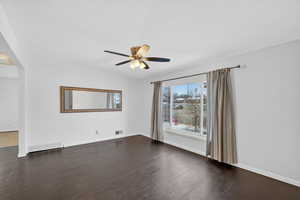 Spare room with ceiling fan and dark wood-style flooring