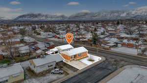 Snowy aerial view with a mountain view and a residential view