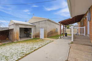View of side of property featuring concrete block siding and an outdoor structure