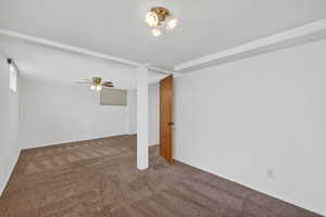Empty room with dark carpet and ceiling fan