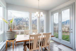 Dining space with a mountain view, healthy amount of natural light, and wood finished floors