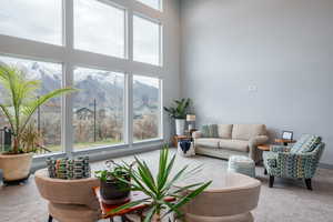 Living area with carpet floors, a high ceiling, and a mountain view