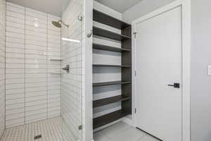 Full bath featuring a shower stall and light tile patterned flooring