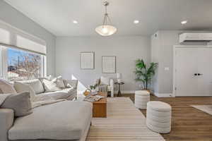 Living room featuring recessed lighting, wood finished floors, and a mini split for heating / cooling