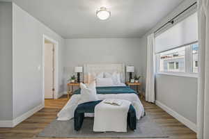 Bedroom with wood finished floors and a textured ceiling