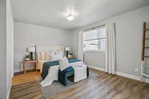 Bedroom with wood finished floors and a textured ceiling