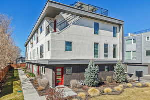 View of side of property with stucco siding, brick siding, and a balcony