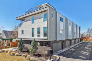 View of side of home featuring brick siding, stucco siding, and a balcony