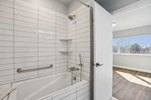 Bathroom with tiled shower / bath and wood finished floors