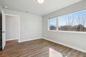 Unfurnished room with dark wood finished floors and baseboards