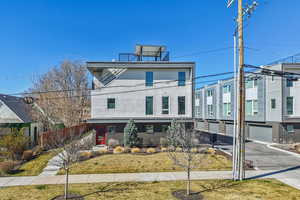 View of front of house with brick siding, a garage, driveway, and stucco siding